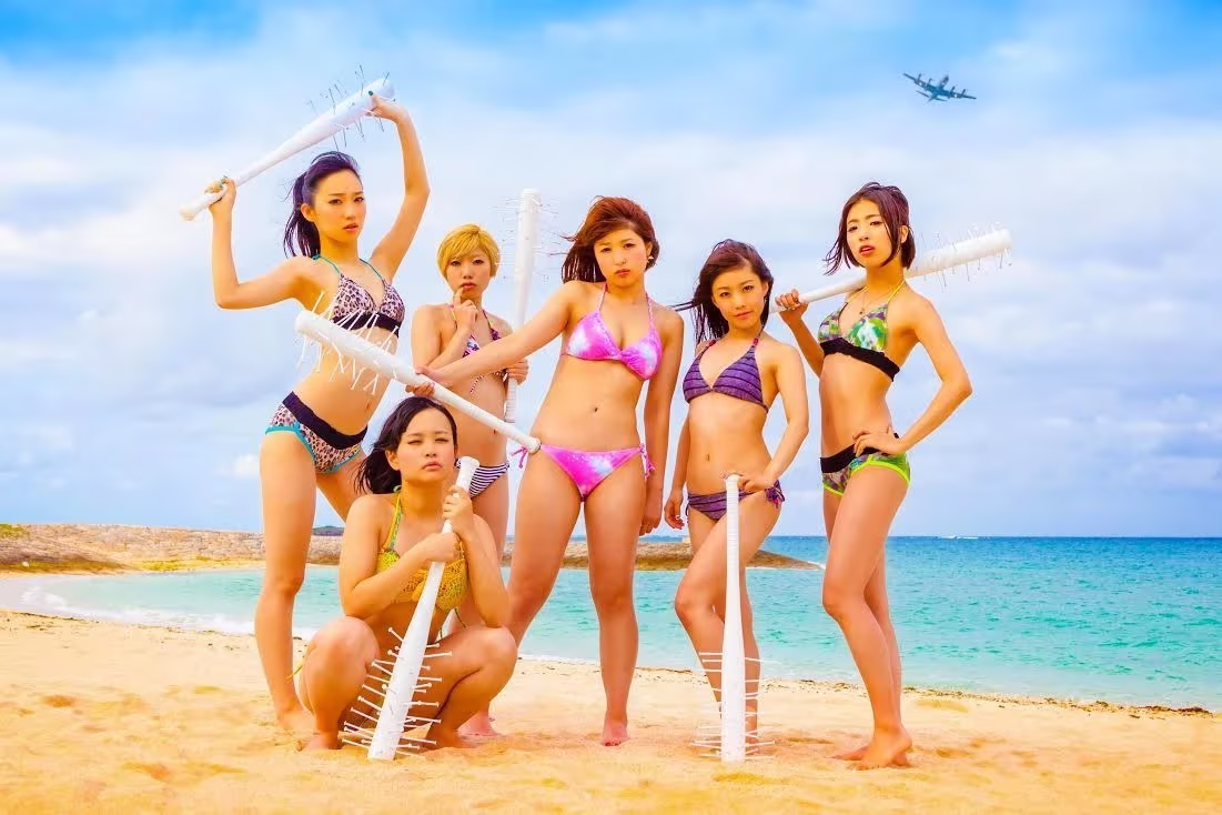 BiS en bikini, sosteniendo bates con púas, en la playa